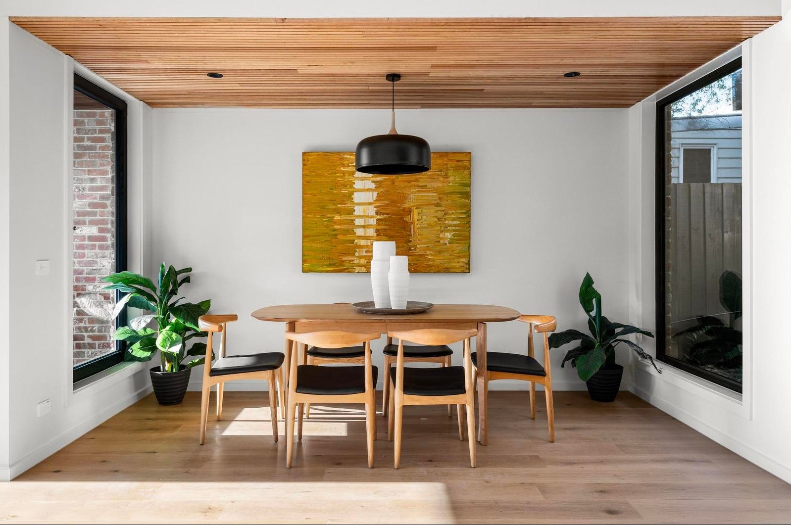 Styled dining room with timber ceiling and gold abstract artwork